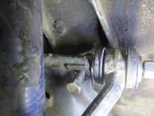 Camber shims being adjusted, showing top wishbone pivot bolts being undone