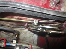 Where the inner cable from the RHS catch connects to a lever on the top edge of the LHS catch, being secured in place by a block and a screw