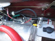 Red wire with extra silicone outer insulater comes from firewall post to DIN socket. The aftermarket socket is actually for a motorcycle application and is reasonably weatherproof.