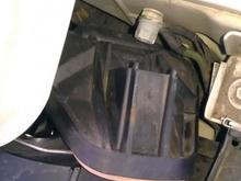 Wiggle cover in place, push cover down to insert tab into wire spring.   :)