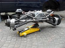 Trolley jack supporting subframe on it's way back into position.