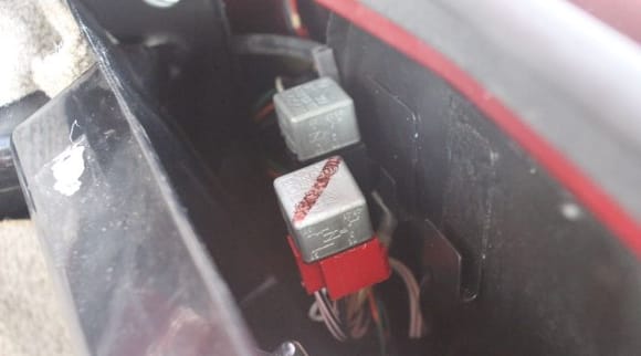 The Black Holder is The Fuel Pump Relay
The Red Holder is The Main Relay
The Relays are located behind a Plastic Panel in the Boot/Trunk near the Bulkhead Fender/Rear Wing.