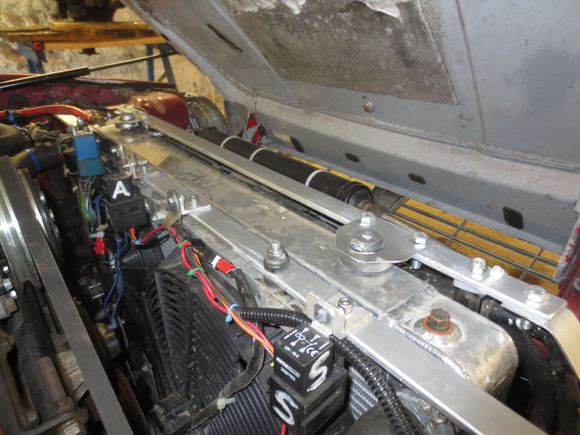 This is my car now, one strut locates the radiator and aircon condensor/oil cooler stack, and there is another locating the fans, which are fixed at the bottom to the chassis cross member to which studs are welded onto which brackets from the fans  are fixed