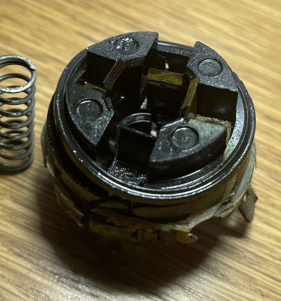 Plastic end cap with electrical tabs at different depths.