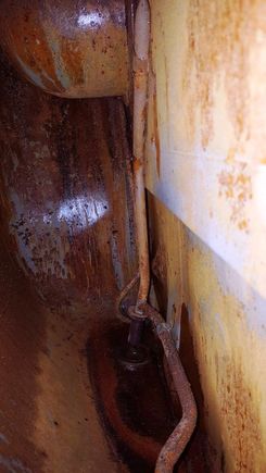 Through the sending unit opening at the rear LH tank.  Bottom of tank is icky.  Most fuel leaked out of that screw; the one above the drain.  WHY, just why would you put a screw there?  It seems to have no purpose.