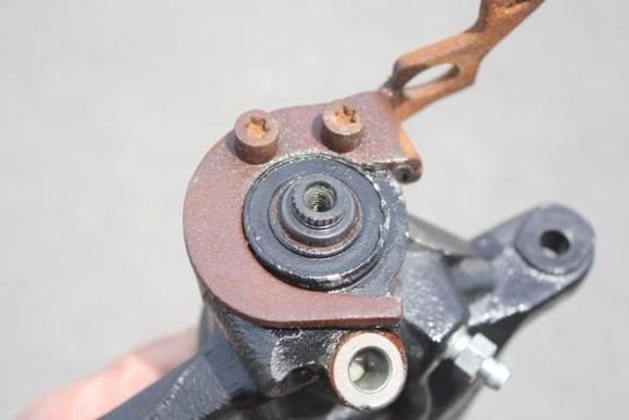 If you look closely, you can see a brown ring between the shaft and the body of the caliper.  That is rust.  The shaft has rusted to the body, resulting in the e-brake not being able to move.  You need to remove this rust.