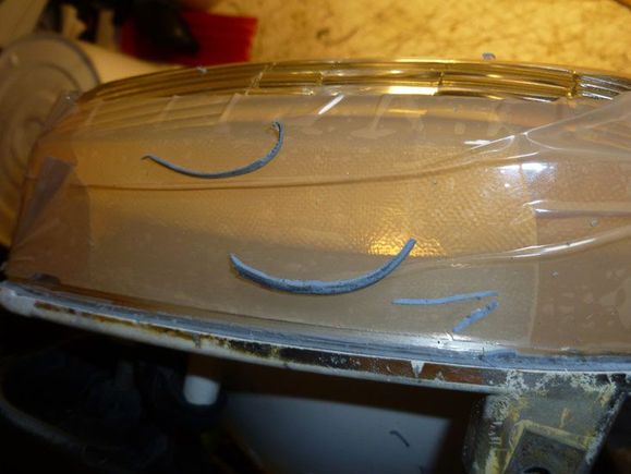 reefing out the old caulk to make room for the new stuff; lens masked off to avoid slop.