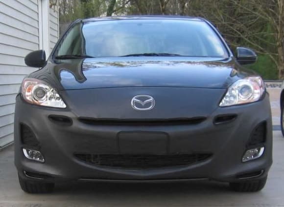 2010 Mazda 3 black mica with front cover 2
* A thicker body-colored grill bar would almost eliminate the smile. The bra covers the grill bar as well as the top part of the grill. If someone could make an aftermarket grill bar that is similar in thickness (or height), it would improve the looks of the front end. That's just my opinion.