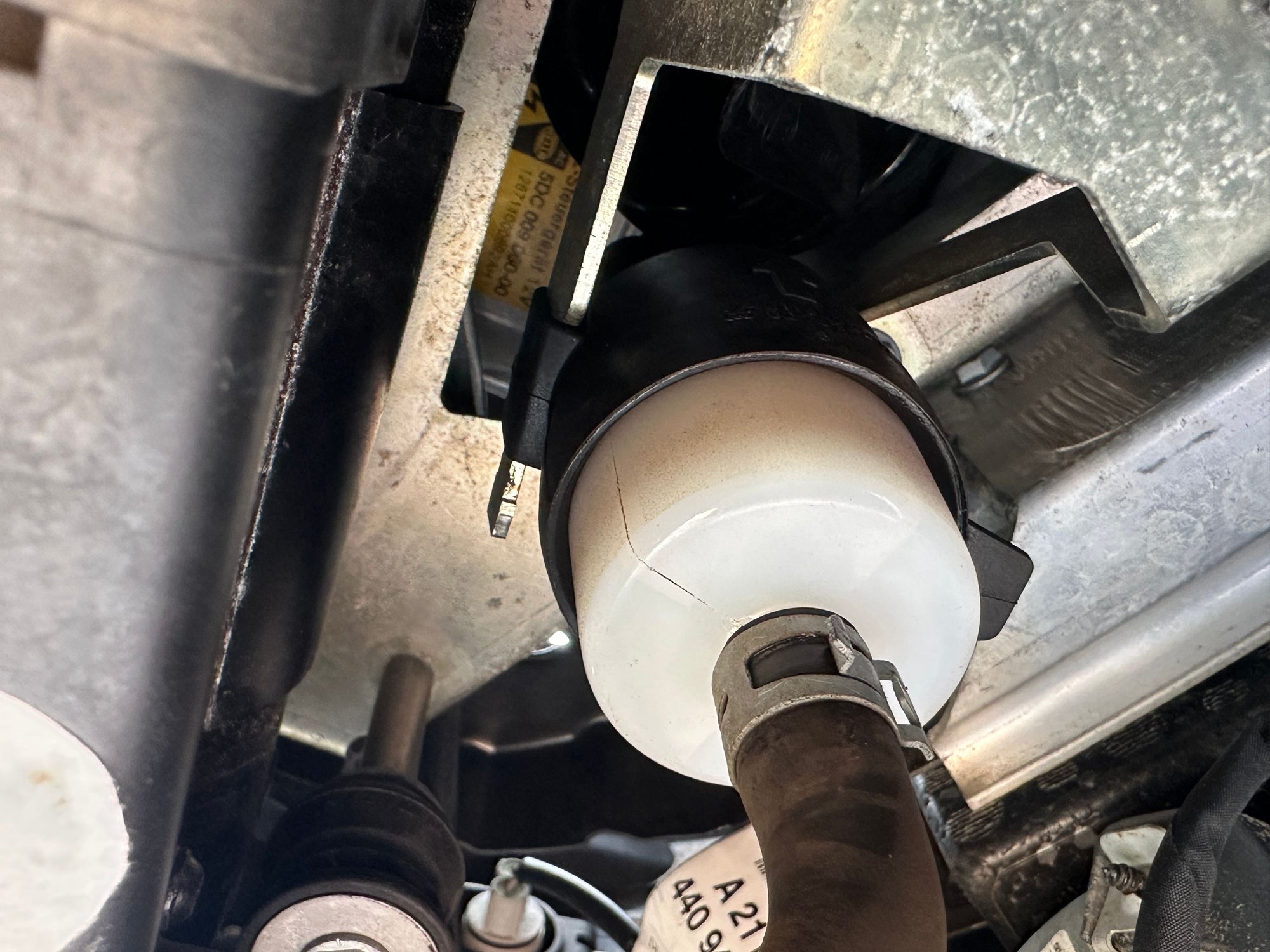 Hose attached to the bottom of the Airmatic air filter with silver spring clamp.  You can see black boot surrounding and holding filter in place.