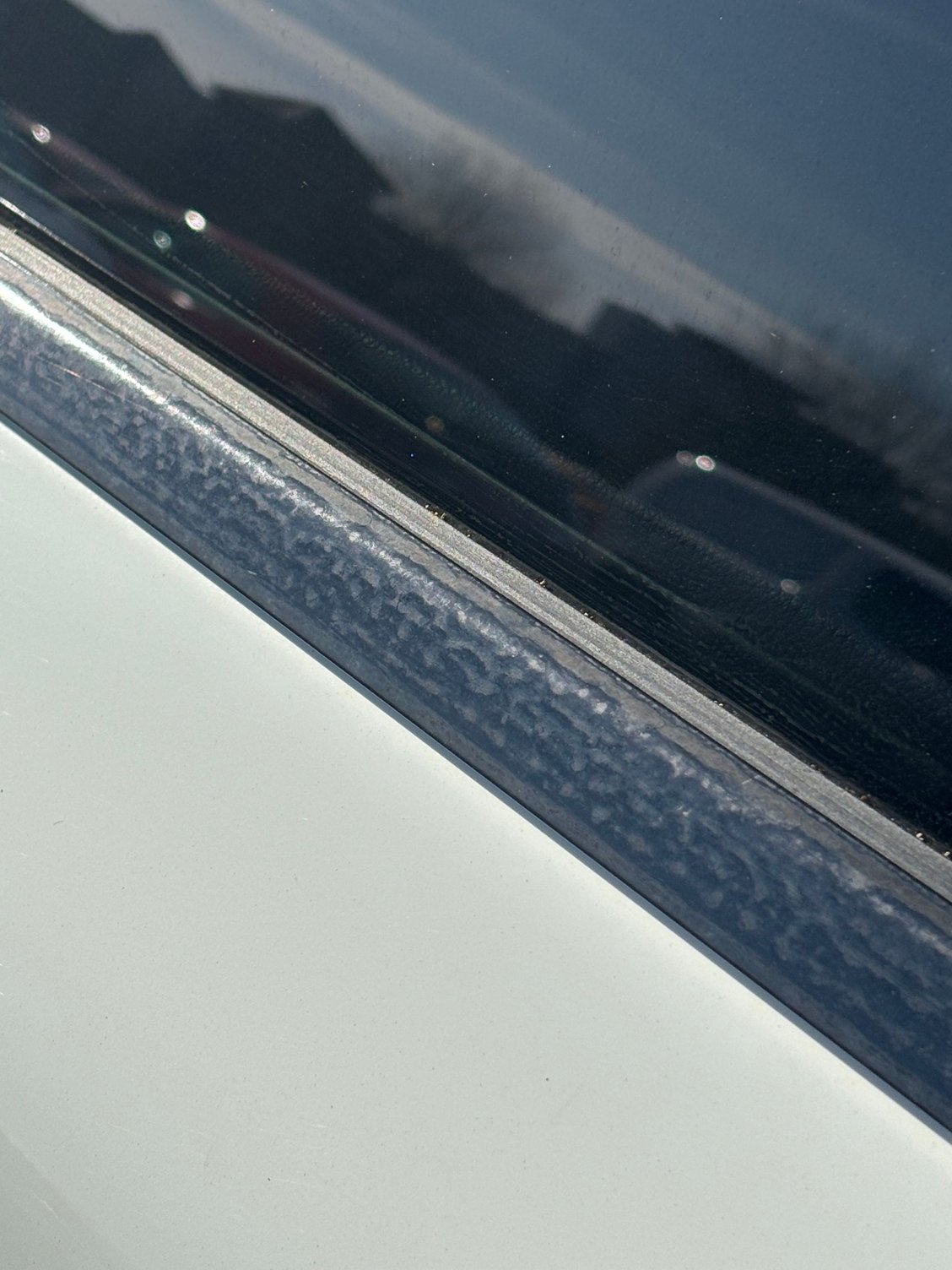 Anyone know how to fix this corrosion on the lower window trim? Its not water spots so I�m unsure of how to go about getting it back to gloss black???