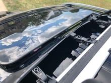 Clearance between moonroof in tilted open position and the wind deflector.  The moonroof slide function occurs inside the roof and does not come outside the vehicle or near the bike rack system. 