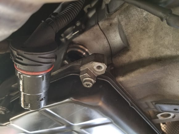 Once the transmission is drained of fluid and the heat shield has been removed you need to remove the plug from the transmission. It requires you to twist the yellow cap to the left  and the pull the black connector out of the transmission.