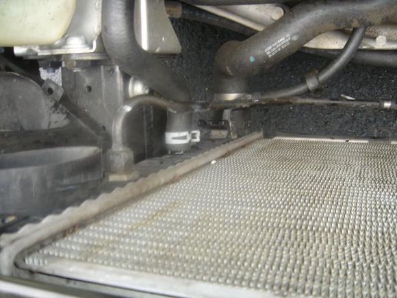 The metal lines are transmission lines. Don't worry, as long as the engine is off you will barely loose any. The work off pressure and no engine running no pressure to spray everywhere. this was the biggest issue trying to research when attempting this. I didn't know how much fluid I would lose but seriously , I maybe lost table spoon full. the other two lines are coolant lines, the middle ones goes to the expanision tank the bottom somewhere under the engine. Just remove it from the rad