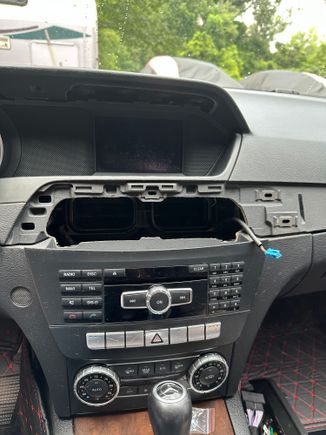 The wood grain trim piece pops right off too. Start away from the radio and work towards it. Inside the vents are two latches one on each end. You can get at them thru the vent or wiggle them lose with some  pressure and patience. Unplug any plugs that you mighty have hooked up to your vents.