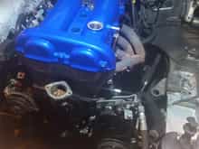 The engine will come out soon, however we got the valve cover powder coated blue for some contrast with the soon to be painted white engine bay and red coilover tops