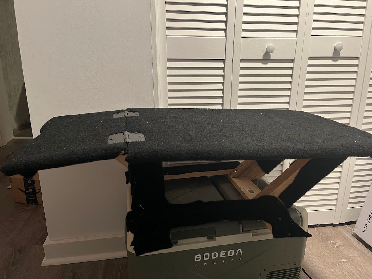I built a deck to replace the front seat, this deck would allow me to get a twin bed length in the car as well as provide additional storage. I added a hinge so I could use the backseat passenger area as storage. The deck also holds a 40 inch folding table firmly.