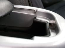 I preformed this fix at the same time when I had originally installed my armrest.
In the photo above: you can see I used a Dremel to chop down the inside lower catch and glued a Neodymium magnet in place....