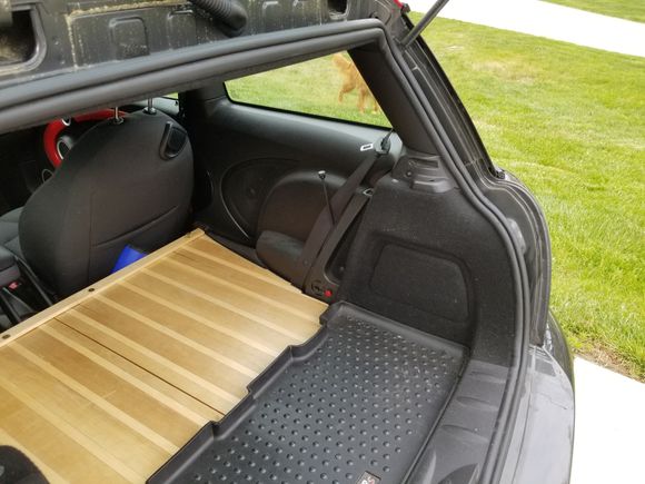 Shows custom rear seat delete flat deck made from 3/8 in thick T&G Ash and Cheery wood.  Note extension for rear coilover damping adjustment, and rear rubber mat.