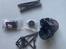 Graphite, front arm and shock tower, spare tranny case with some parts – not complete