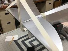 Here, the fin is epoxied in place and stabilized while the glue cures.