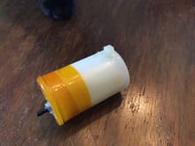 This has a fancy 90 fitting pressed in through an undersize hole, but most of them I make with silicone tubing through a tight fitting punched hole.They work nicely on  muffler pressure and on crankcase pressure.

The tape is Kapton - not because the film is special, that's not necessary. But it comes with a silicone adhesive, so on first application on a non-oily surface it sticks tight and spilled fuel doesn't bother it.