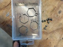 Mild steel straps.  Shape must be accurate or they will loosen in service.