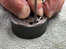 The steel block is used to support the ring square and true to the file.  Some I just happened to have on hand.
  A one inch or better hardwood board with a hole just a bit larger than the file would work fine too.
    Smooth easy strokes with light to medium squeeze are best. Check gap after every stroke or two remember you are cutting both ends at once.