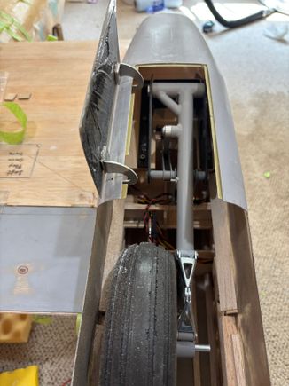 Left front main gear door done. Like original, offset hinges allow wheel to move without hitting gear door. Only 5 more gear doors to hinge