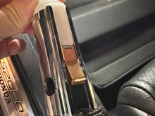 This is the tab you need to push. There is a bump on the other side of the housing that help to align the button but you do not need to squeeze it. 

Well pushing the button out, it helps to angle it slightly towards the door.