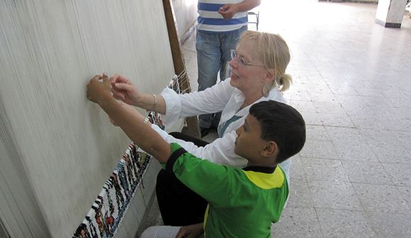 725 Two children weaving rugs.JPG