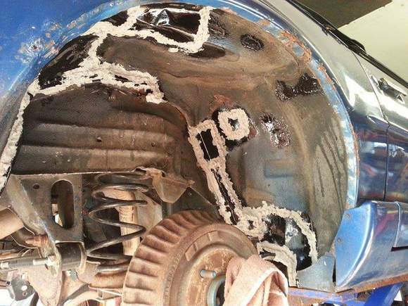 Front of passenger side rear wheel well after body sealant but before under coating.