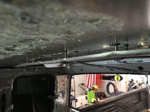 In this photo, I JB welded bolts to the roof skin and tried to thread nuts on to pull it back up.  It just pulled the skin down.